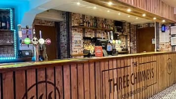 A bar area with wooden paneling, a dog menu sign, and a patterned floor.
