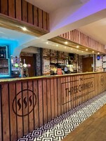 A bar area with wooden paneling, a dog menu sign, and a patterned floor.