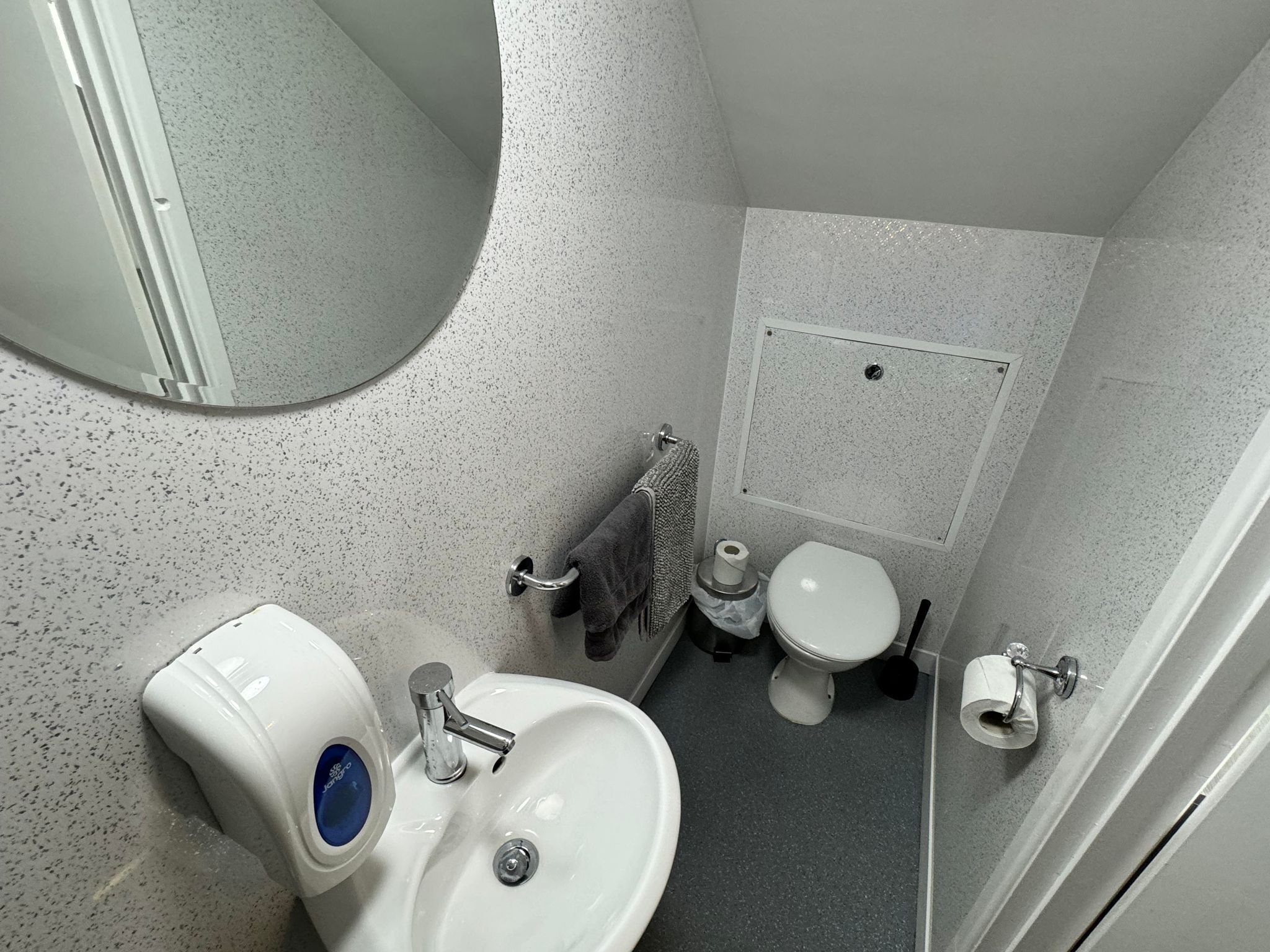 A bathroom with a white sink, a toilet, and a shower area.