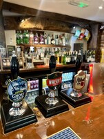 A bar with three beer taps labeled Ghost Ship, Wherry, and Abbott Ale.