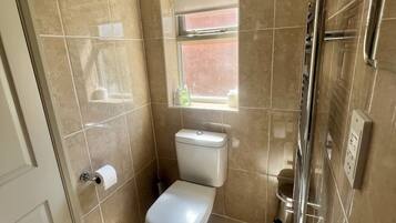 Un baño con inodoro, lavabo y ducha.