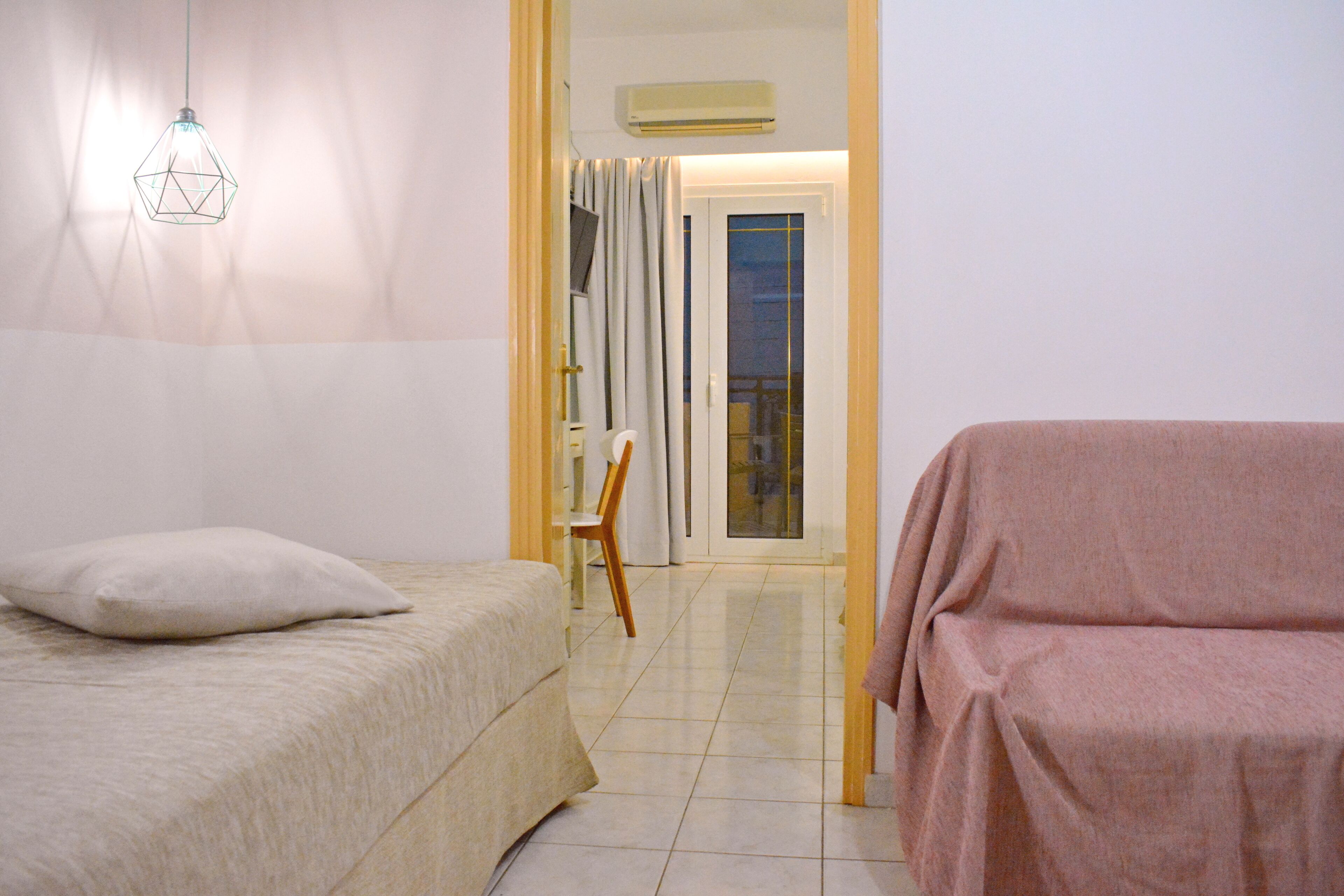 Una camera da letto con un letto, una sedia e un divano.