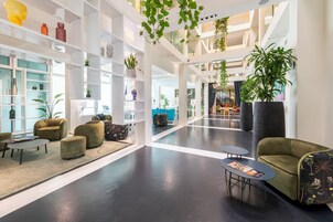 Un lobby amplio con techos altos, muebles modernos y plantas de interior.
