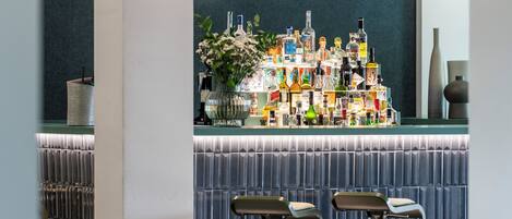 A bar area with a variety of liquor bottles and two bar stools.