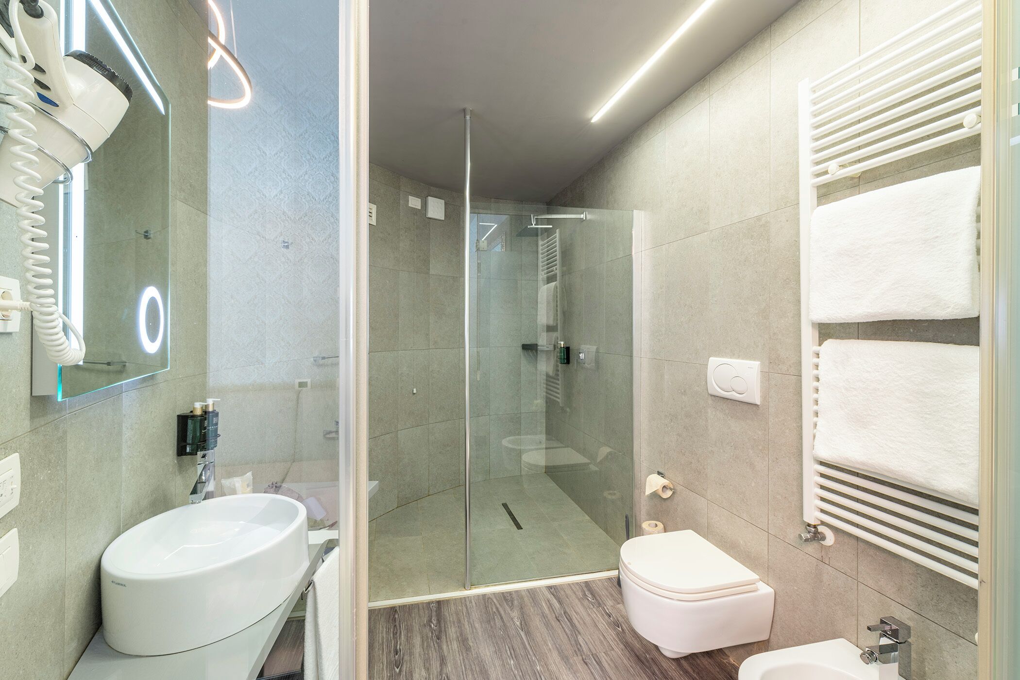 Une salle de bain moderne avec une douche à parois de verre, un lavabo blanc et des toilettes.