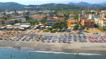 En la playa, camastros, sombrillas y 2 bares en la playa