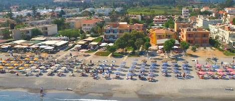 En la playa, camastros, sombrillas y 2 bares en la playa