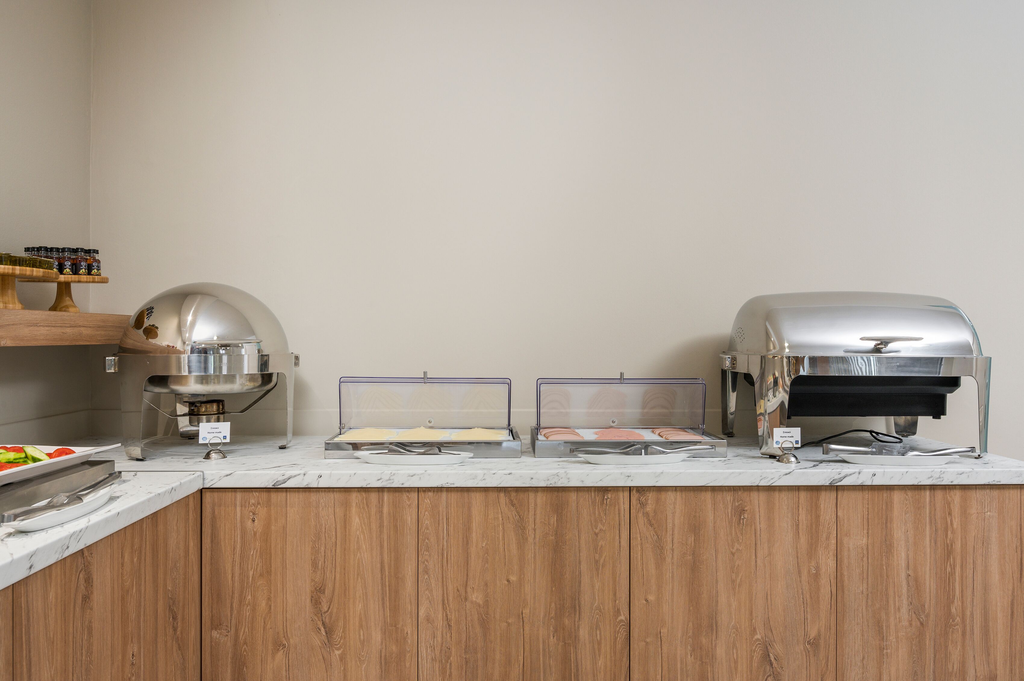A buffet setup with a grill, a food display, and a condiment station.