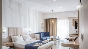 Une chambre d’hôtel comprenant un lit, un canapé, une petite table, une chaise, un bureau et un miroir.