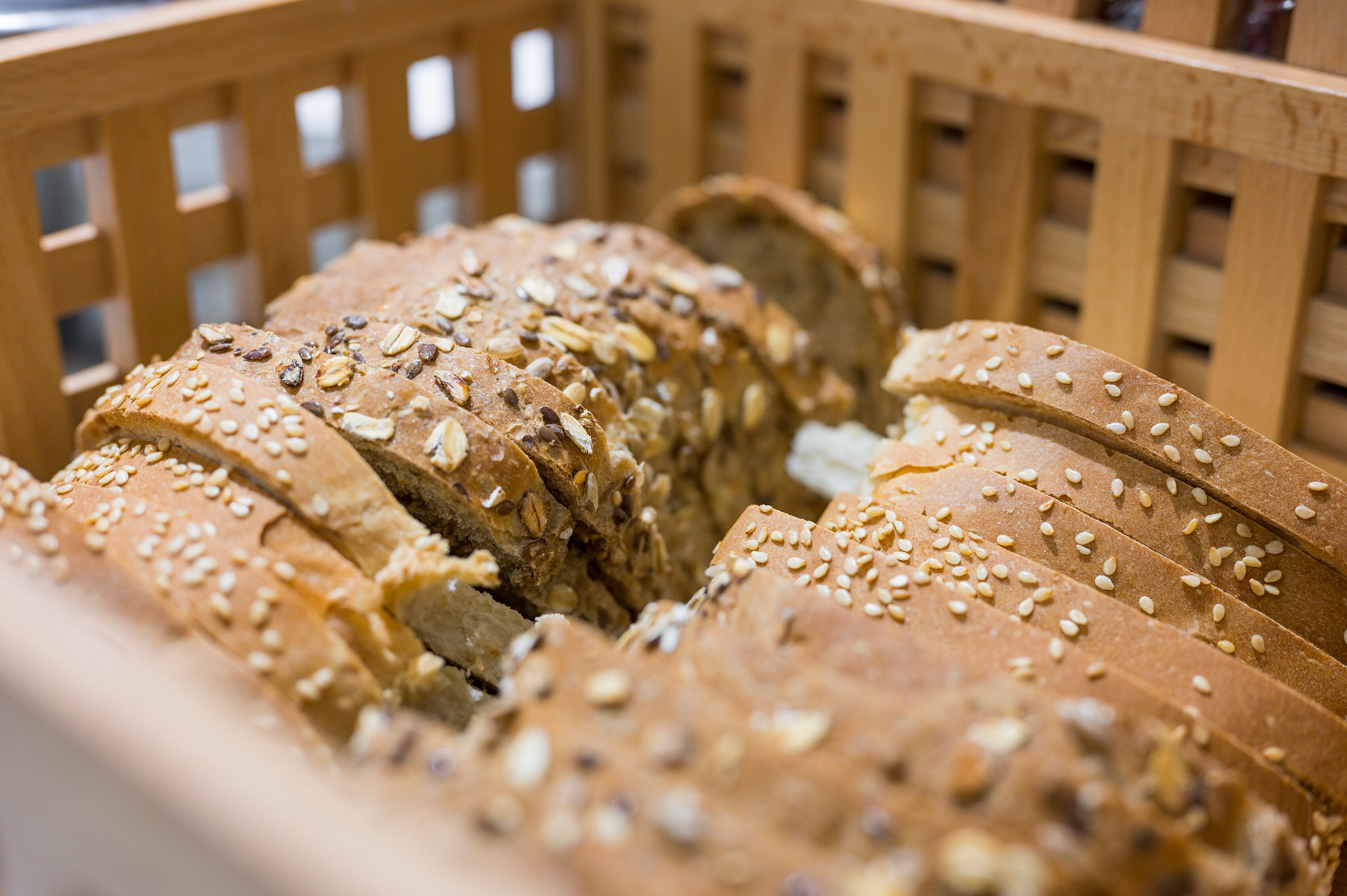 Ein Holzkorb, gefüllt mit geschnittenem Mehrkornbrot.
