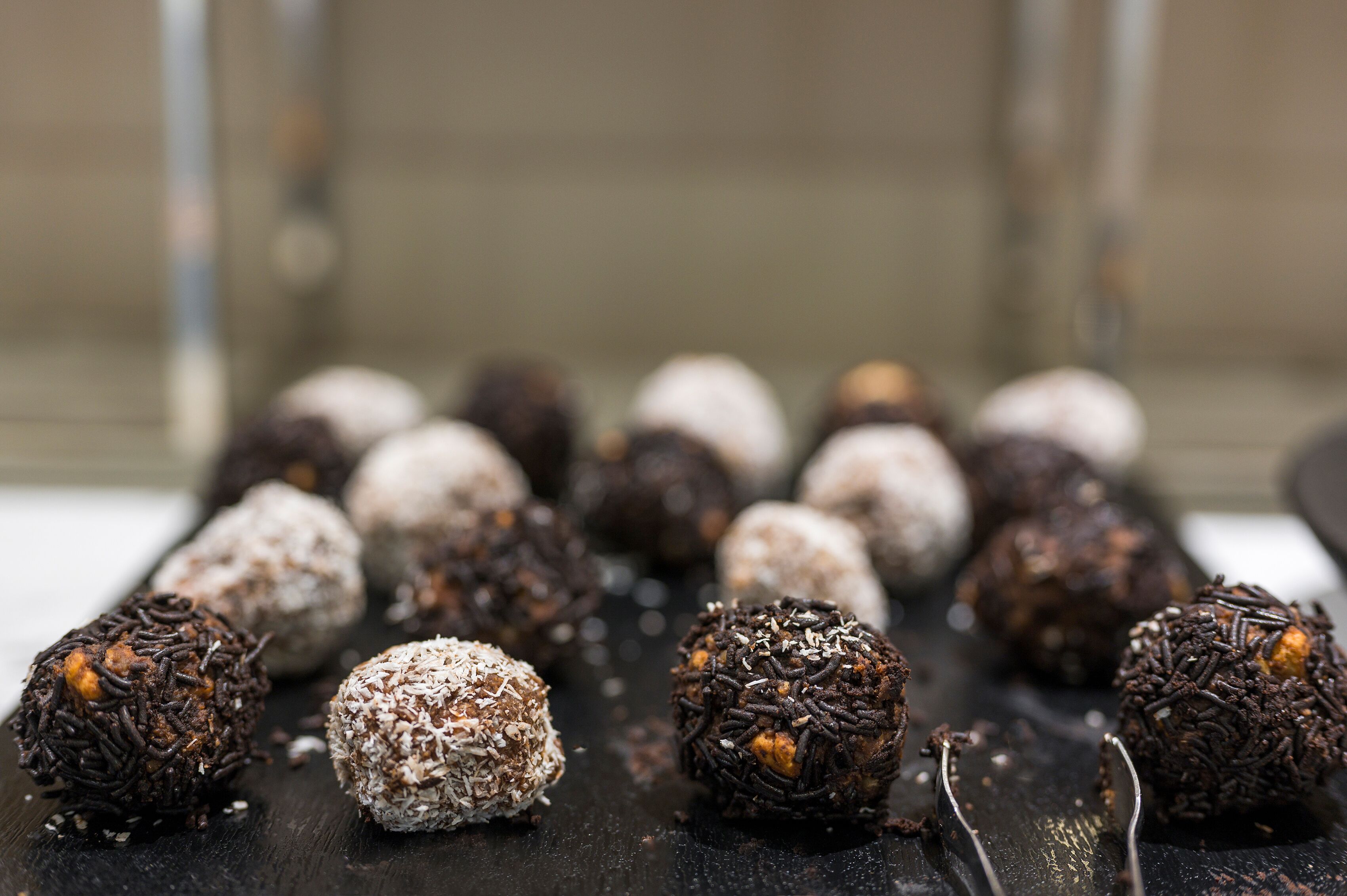Une assiette remplie de truffes de différentes sortes, posée sur une surface sombre.