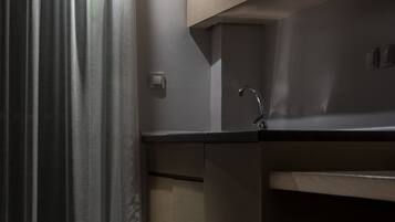 A modern kitchen with a stainless steel sink, a light switch, and a wooden countertop.