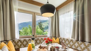 Una mesa con artículos para el desayuno y una vista de montañas a través de la ventana.