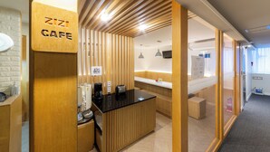Ein Zizi Cafe mit Holzvertäfelung, einer schwarzen Arbeitsplatte und einem modernen Design.