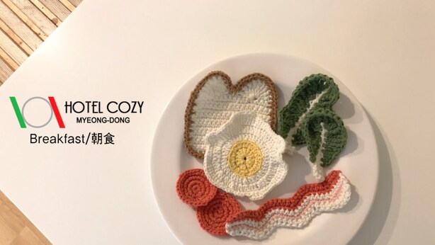 Ein Teller mit gehäkelten Speisen und das Logo von HOTEL COZY MYEONG-DONG.