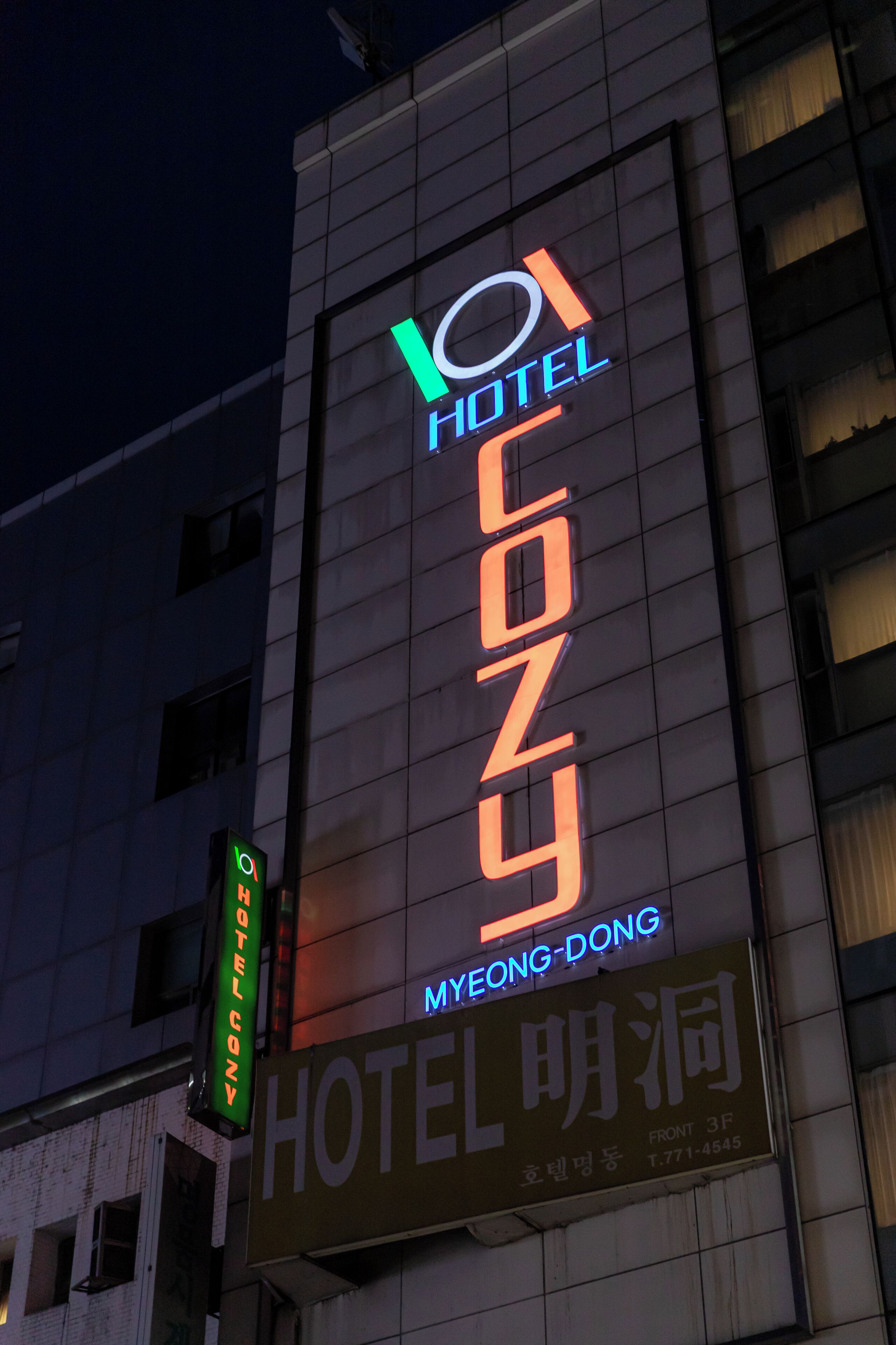 A hotel sign with the name "HOTEL MYEONG-DONG" and a neon sign above it.