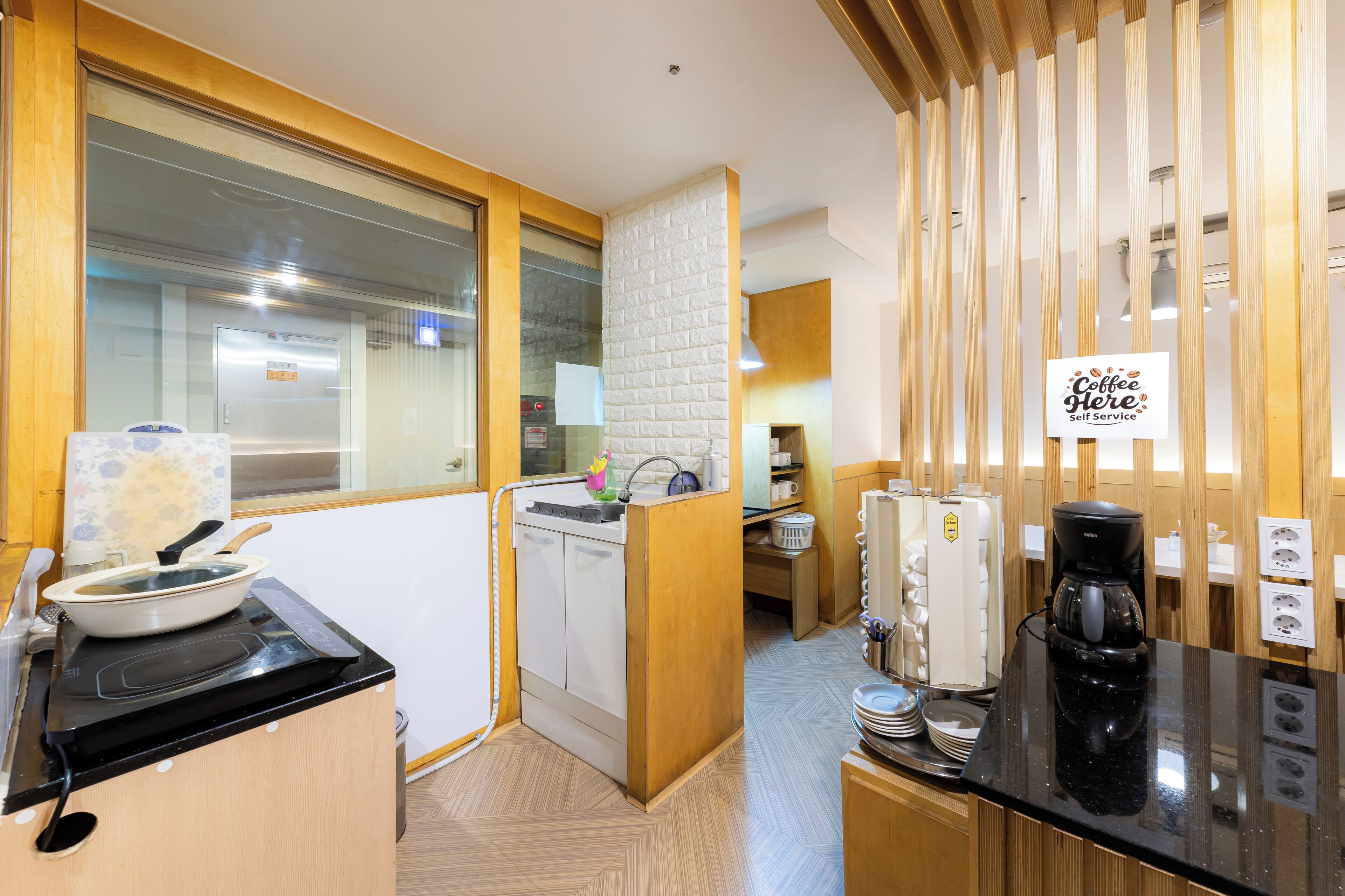 A compact kitchen with a stove, sink, and coffee maker.