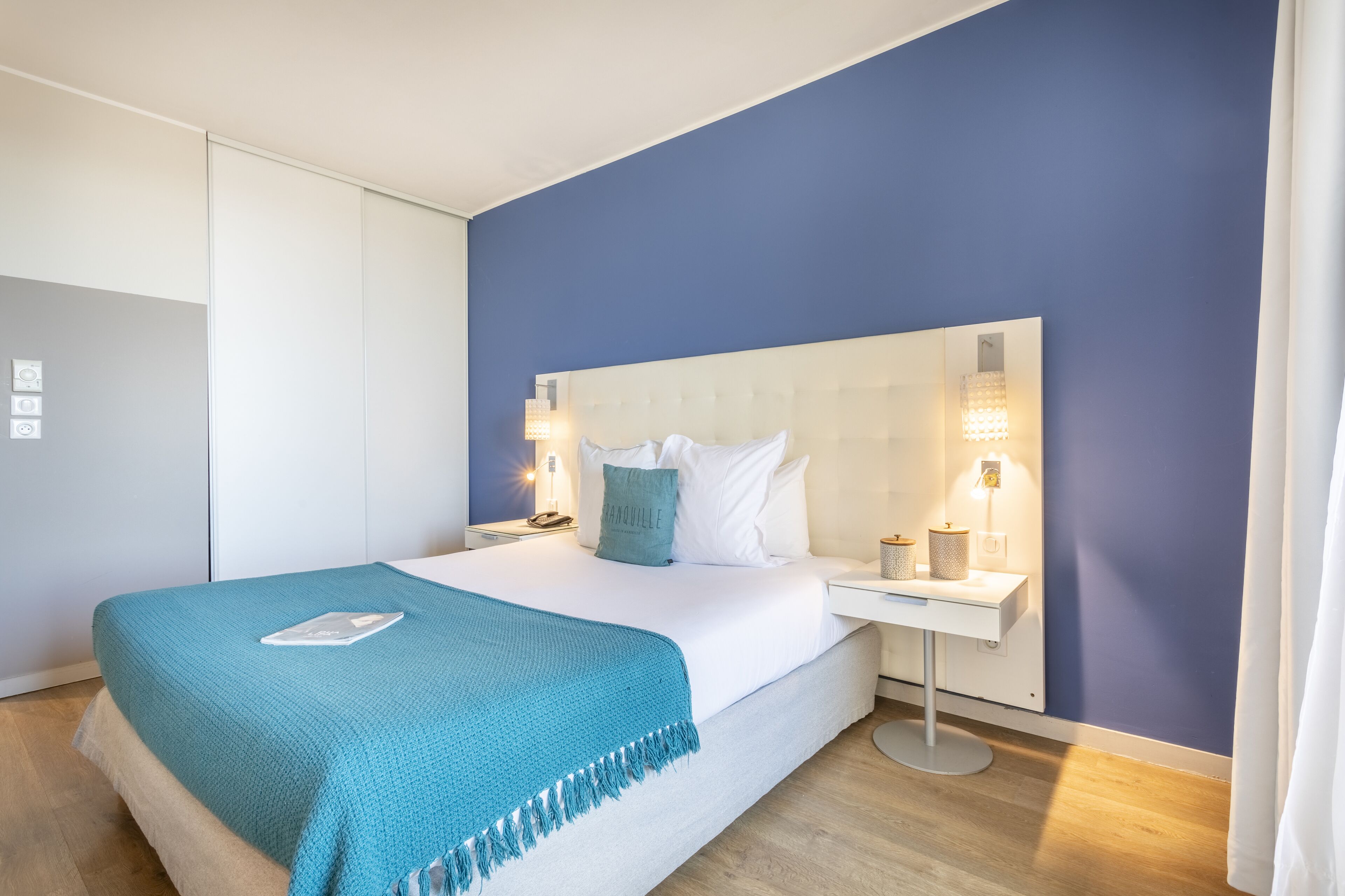 Ein modernes Schlafzimmer mit Bett, Nachttischen und einem Beistelltisch.