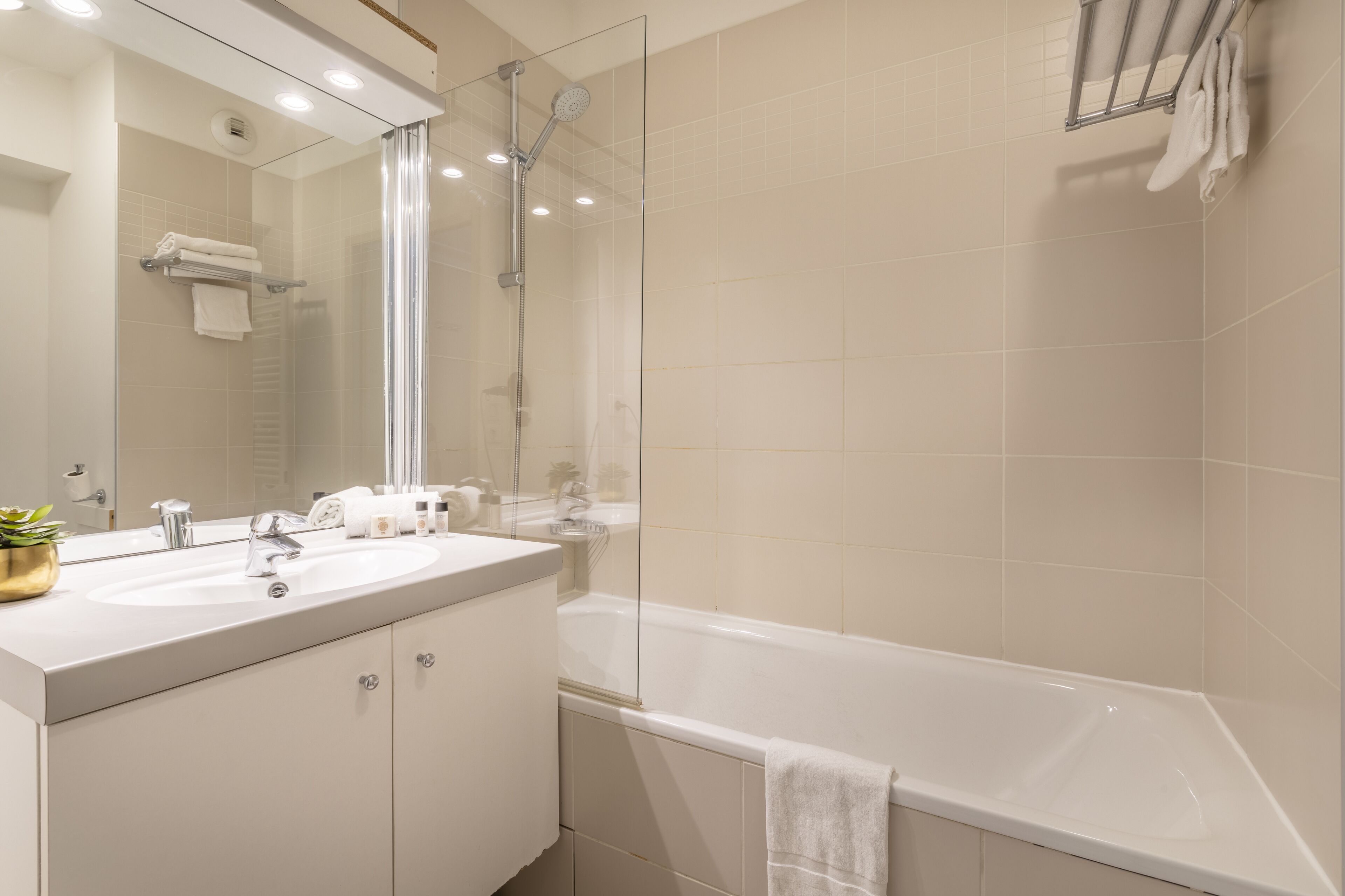 A modern bathroom with a glass-enclosed shower, a white sink, and a bathtub.