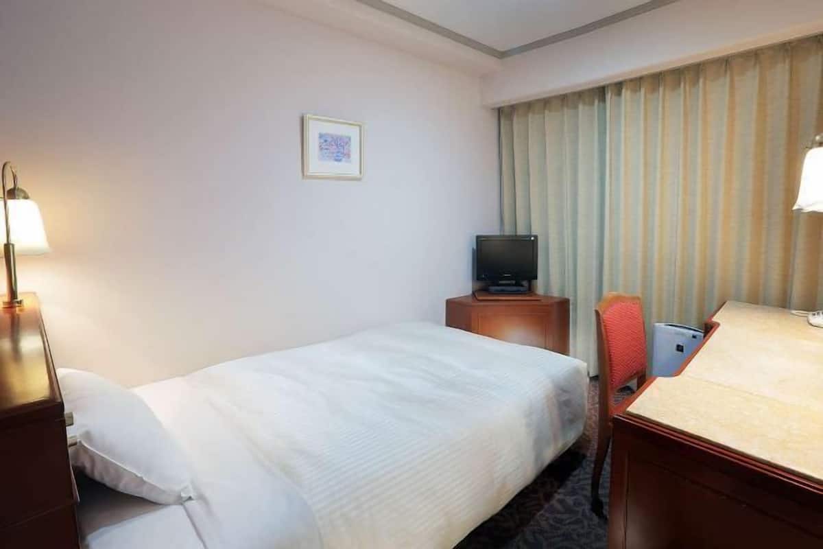 Edredón, escritorio y espacio para trabajar con laptop