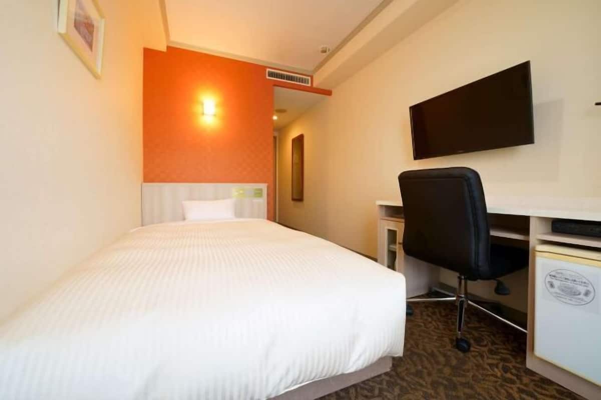 Edredón, escritorio y espacio para trabajar con laptop