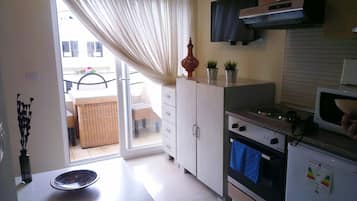 Compact Studio Apartment | Private kitchen | Full-sized fridge, stovetop, cookware/dishes/utensils