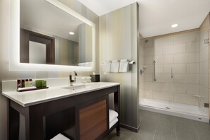 Un baño moderno con un espejo grande, dos lavabos y una zona de ducha.