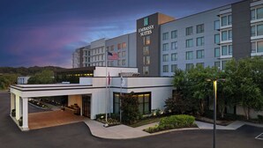 Un hotel moderno con techo plano, varios pisos y un llamativo letrero de 'Embassy Suites'.