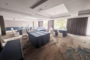 A conference room with a large table, white chairs, and a carpeted floor. - Tianyue Hotel (Chengdu)