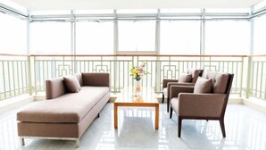 A modern living room with a sofa, armchairs, and a coffee table. - Tianyue Hotel (Chengdu)