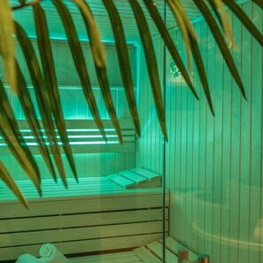 Una sala de sauna con bancos de madera y un panel de vidrio.