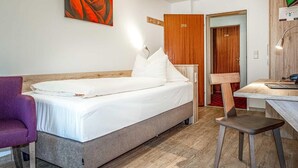A bedroom with a bed, a desk, a chair, and a television. - Hotel AM Schlosspark (Ismaning)
