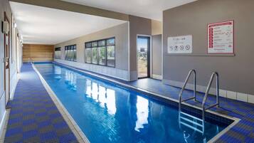 A swimming pool with a blue tiled floor and a lifeguard stand.