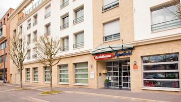 Un edificio de varios pisos con un letrero que dice 'Residhome', indicando una propiedad residencial.