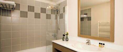 Ein modernes Badezimmer mit Badewanne, Dusche und Waschbecken.