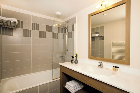 A modern bathroom with a bathtub, shower, and sink. - Residhome du Théâtre (Valenciennes)