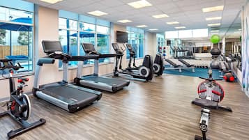 A gym with treadmills, elliptical machines, and free weights.