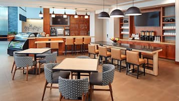Un restaurant moderne doté d’un bar, d’un espace salon et d’un coin café.