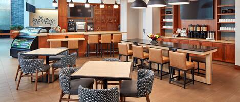 A modern restaurant with a bar area, seating, and a coffee station.