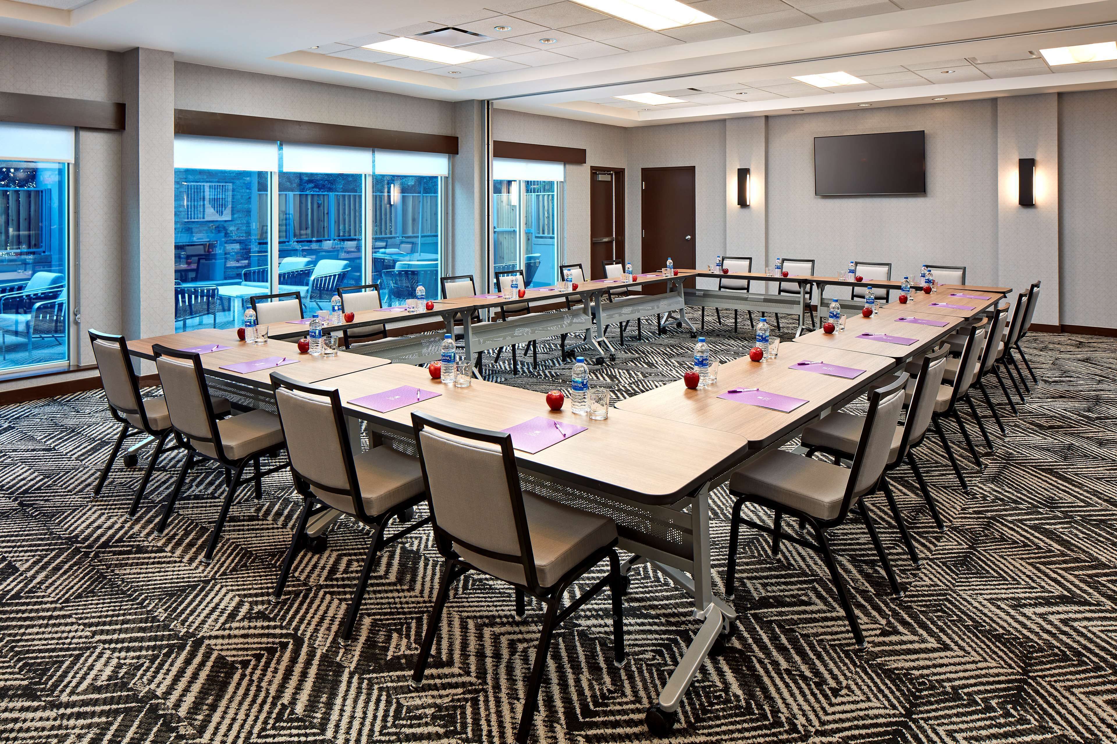 A conference room with a long table, chairs, water bottles, and nameplates.