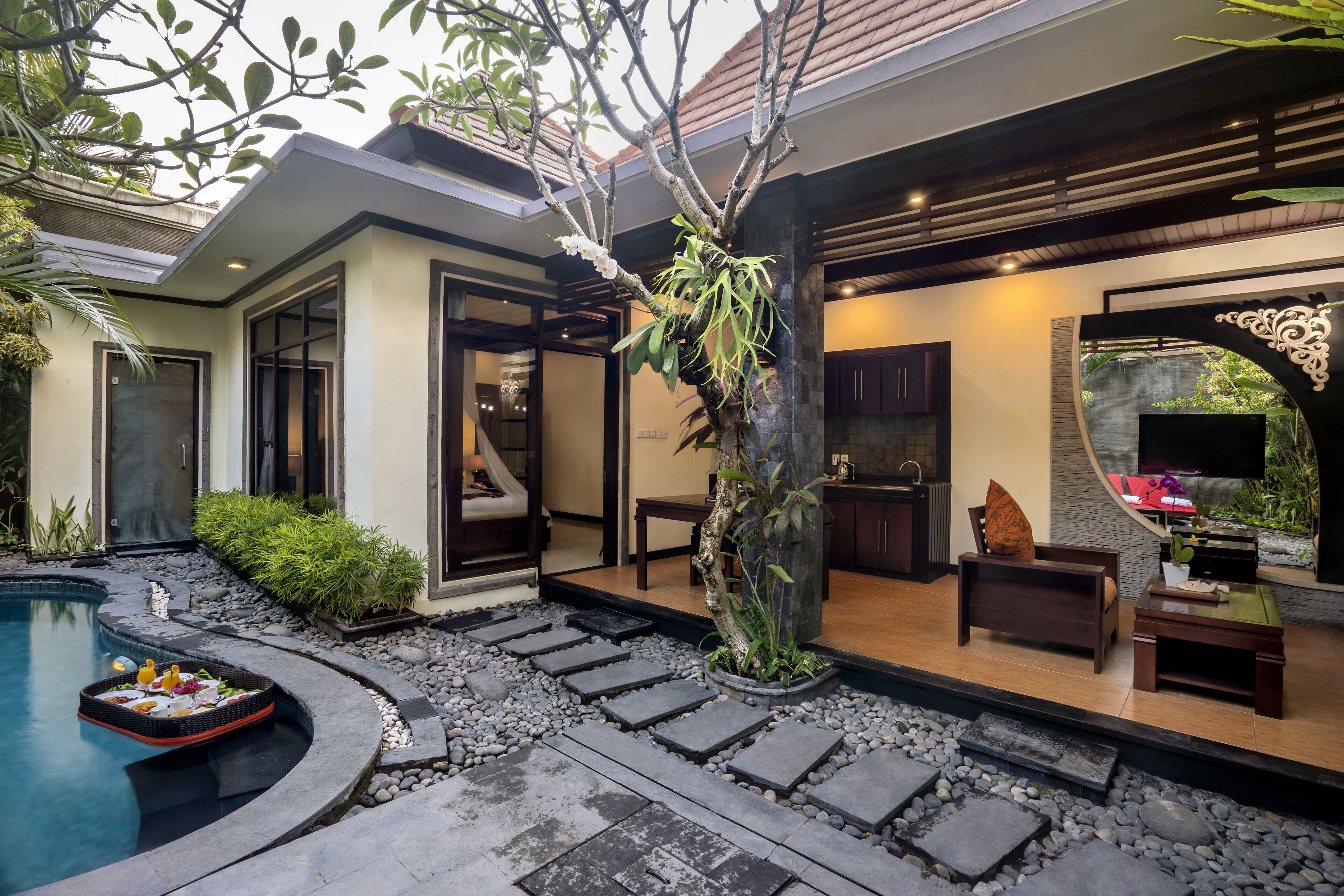 A modern outdoor area with a pool, stone steps, and seating.