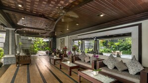 A spacious indoor area with wooden flooring, a ceiling fan, and a seating area with sofas and tables. - The Bali Dream Villa Resort Echo Beach Canggu (Pererenan)