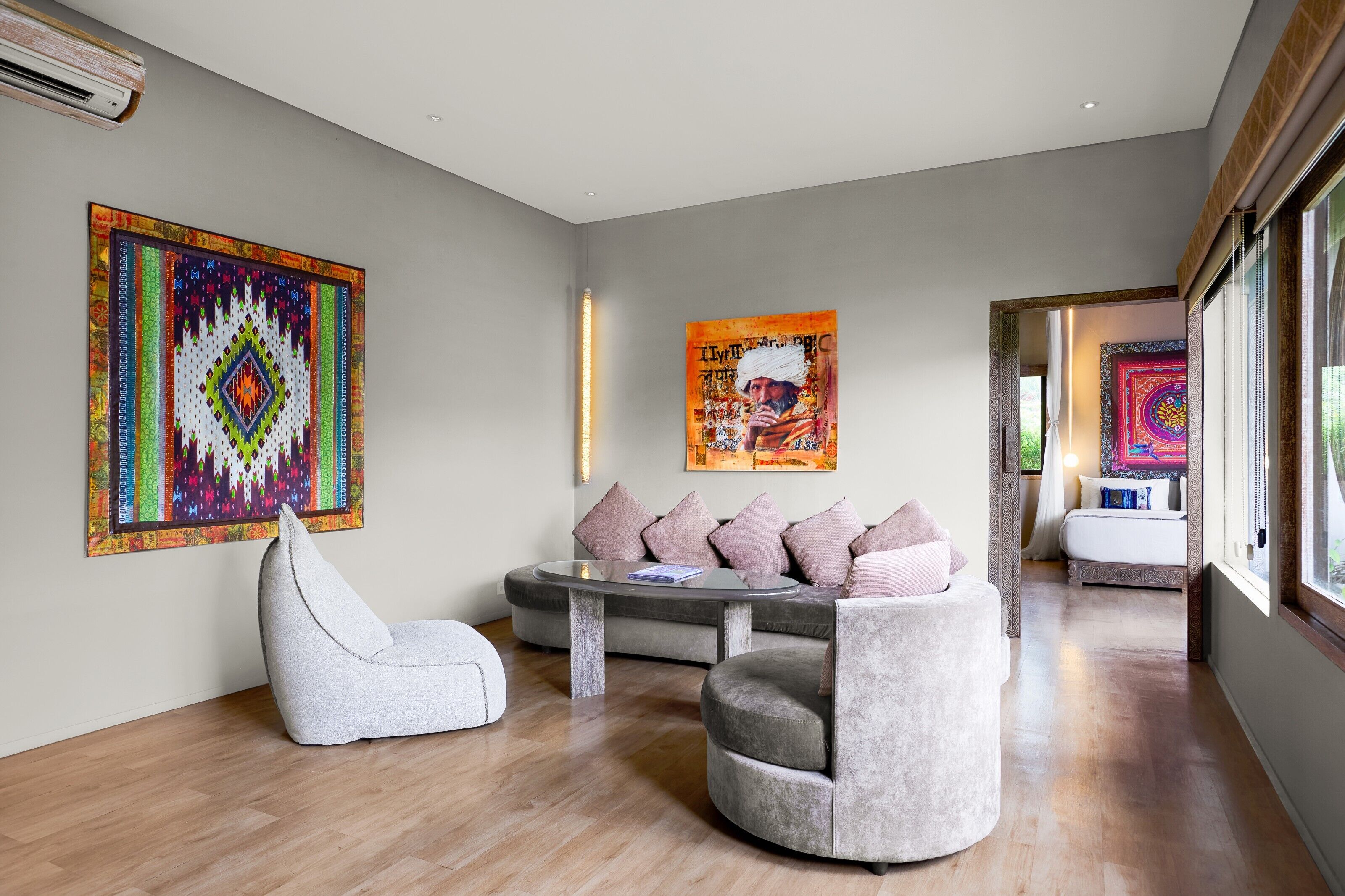 A modern living room with a sofa, a chair, and two artworks on the wall.