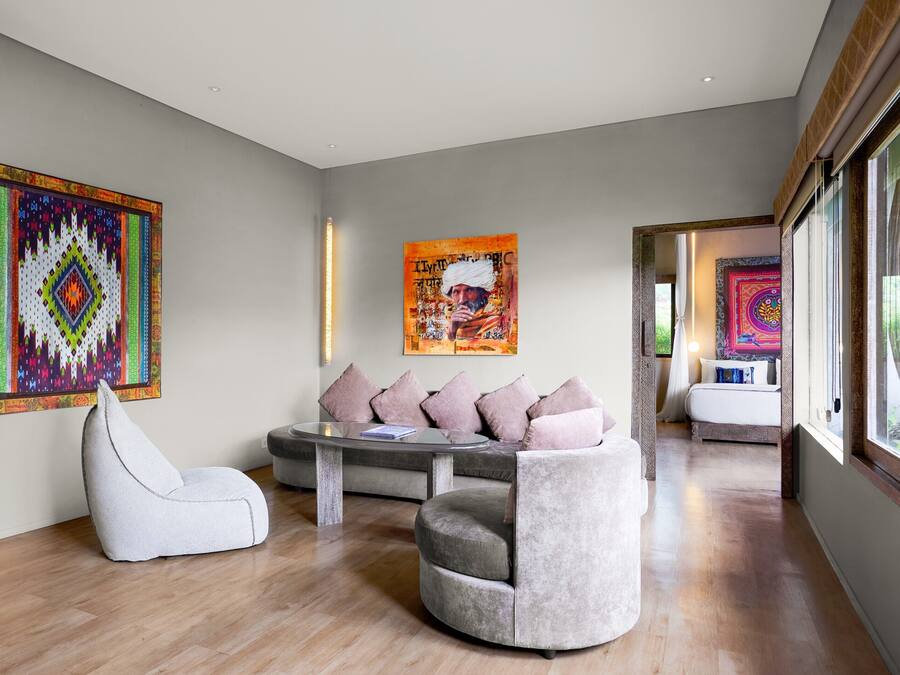 A modern living room with a sofa, a chair, and two artworks on the wall.