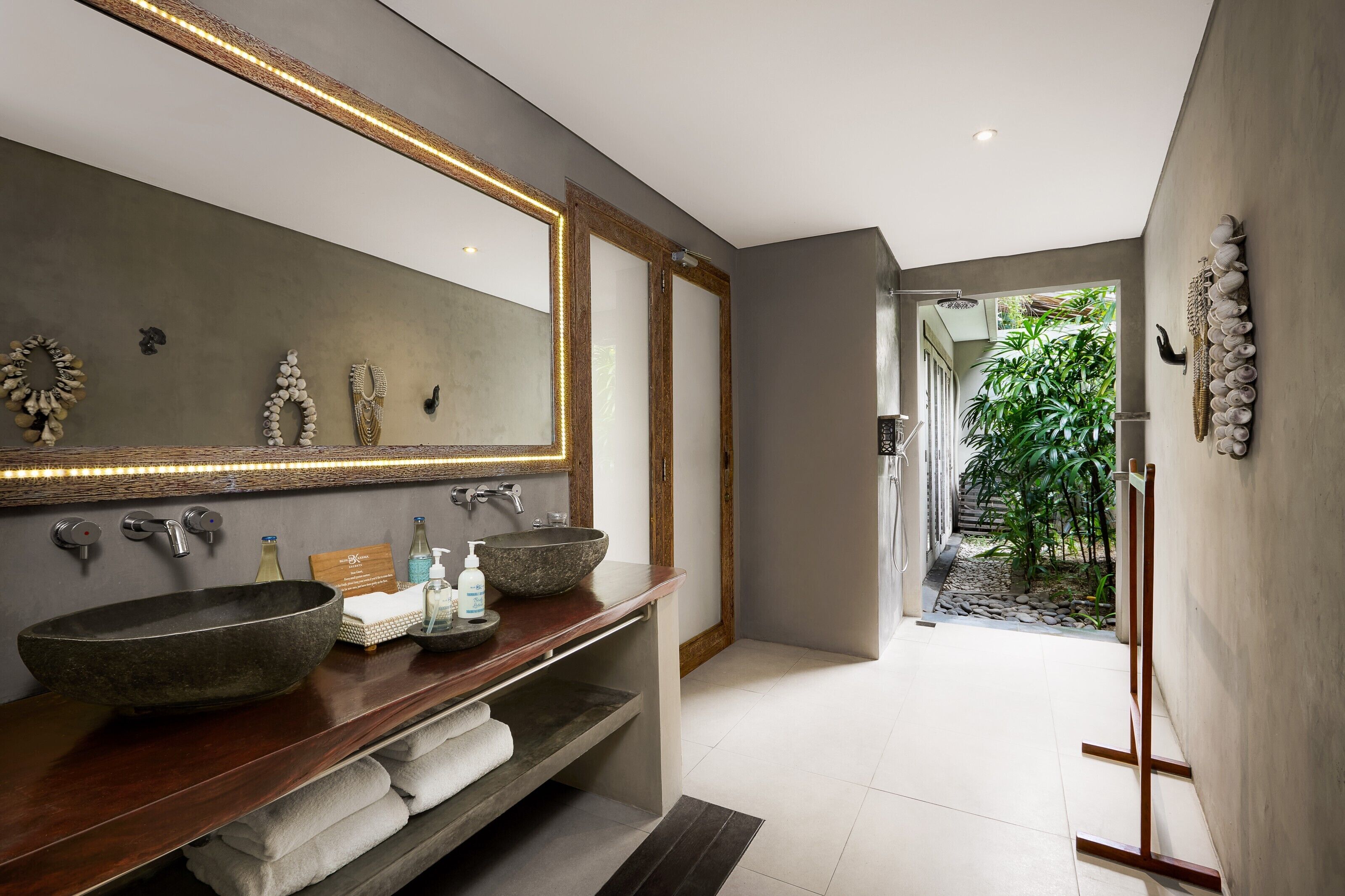 Un baño moderno con un espejo grande, dos lavamanos y un mueble de tocador de madera.