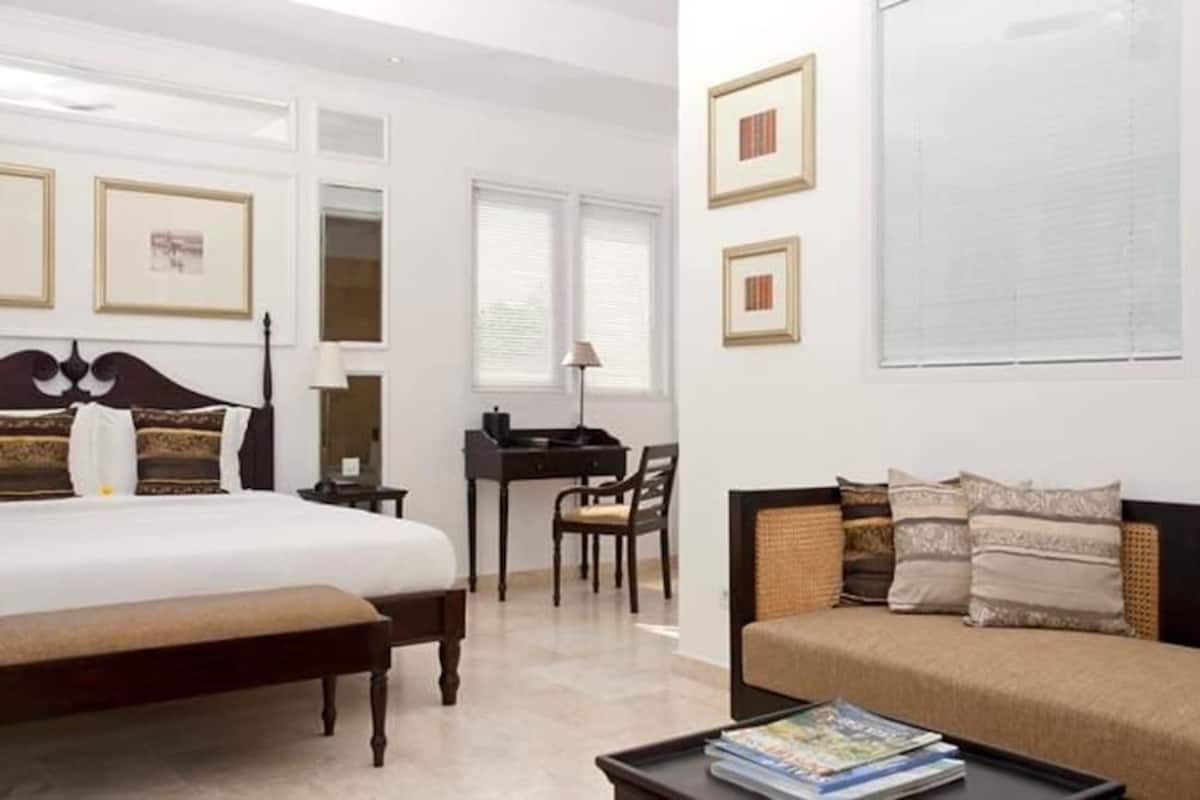 Une chambre à coucher avec un grand lit, une table de chevet, un bureau et un canapé.