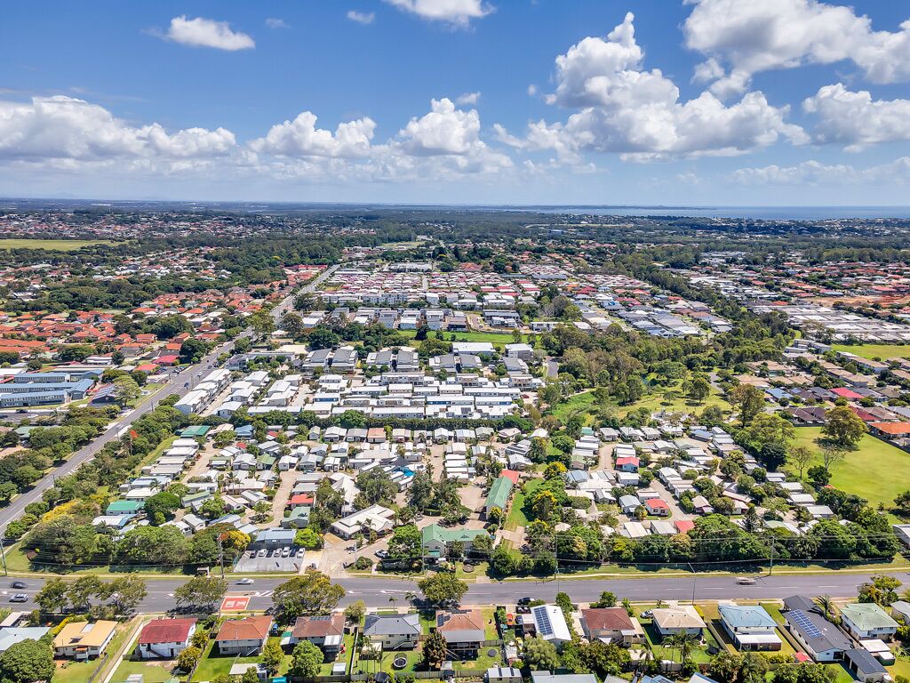 An aerial view of a residential area with numerous houses, roads, and green spaces.