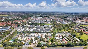 Vista aérea de una zona residencial con numerosas casas, calles y espacios verdes.