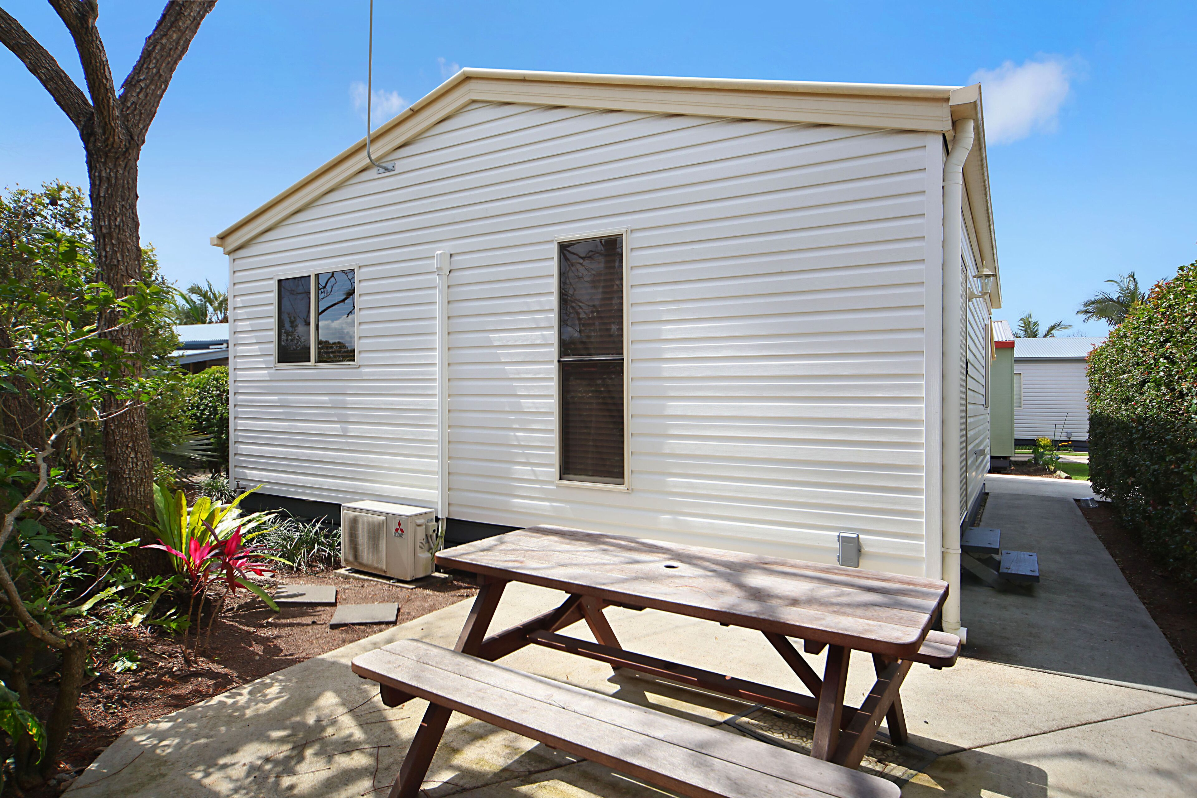 A mobile home with a picnic table in front.
