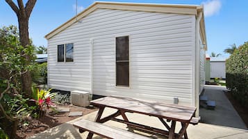 A mobile home with a picnic table in front.